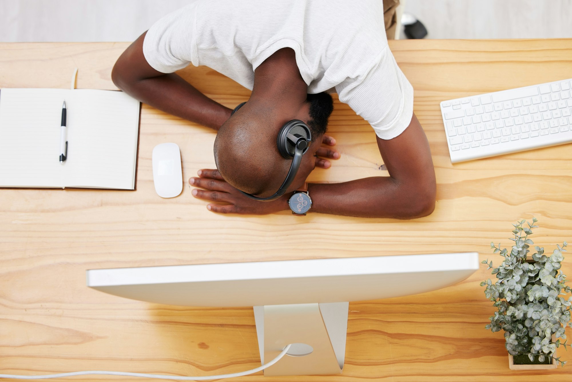 Being a human being is tiring. Shot of a young businessman taking a nap at his desk.