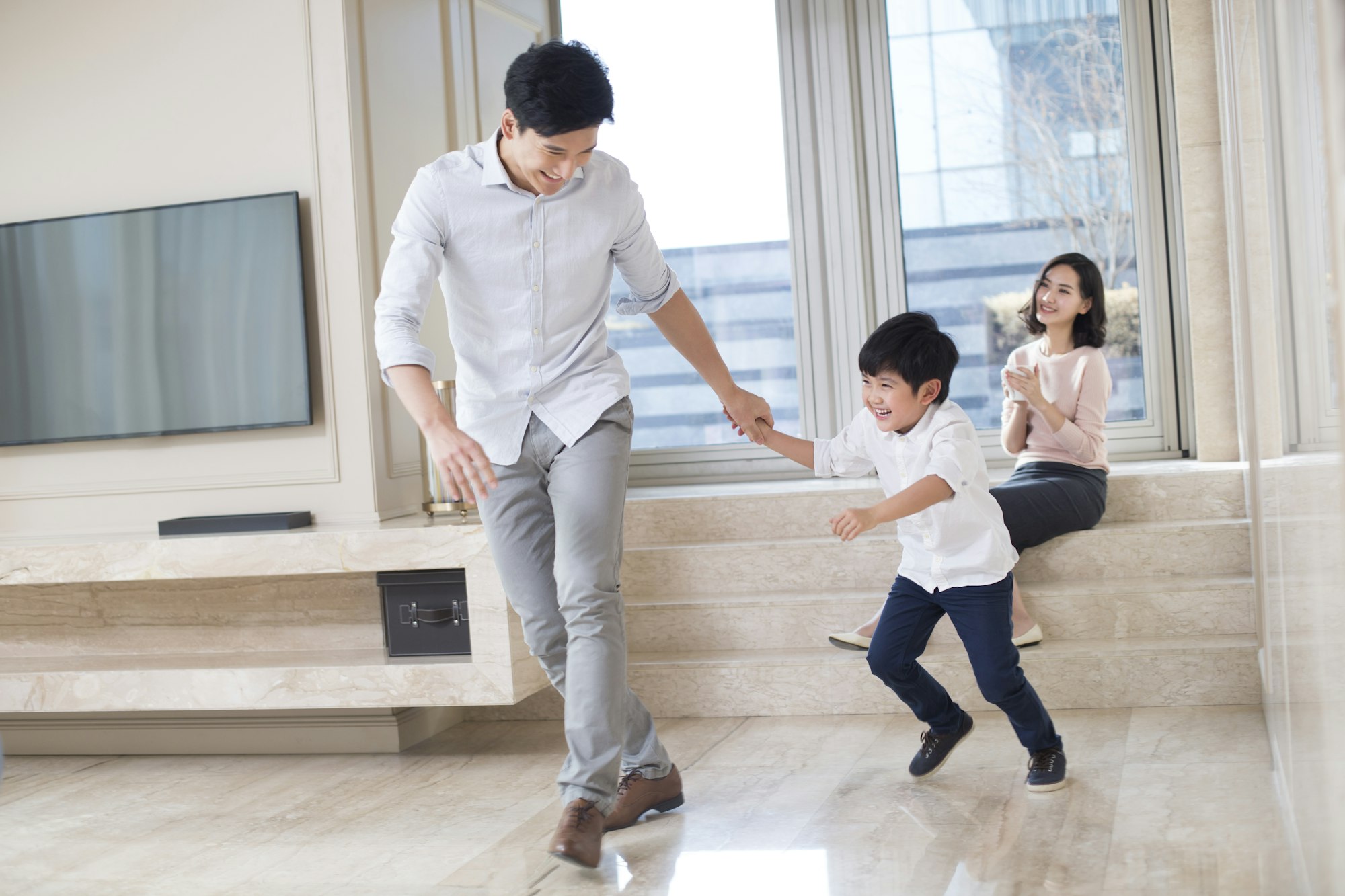 Cheerful father and son playing in the living room