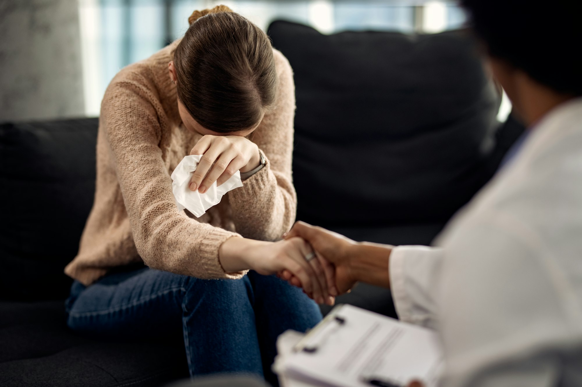 Depressed woman seeking solace from her psychotherapist.