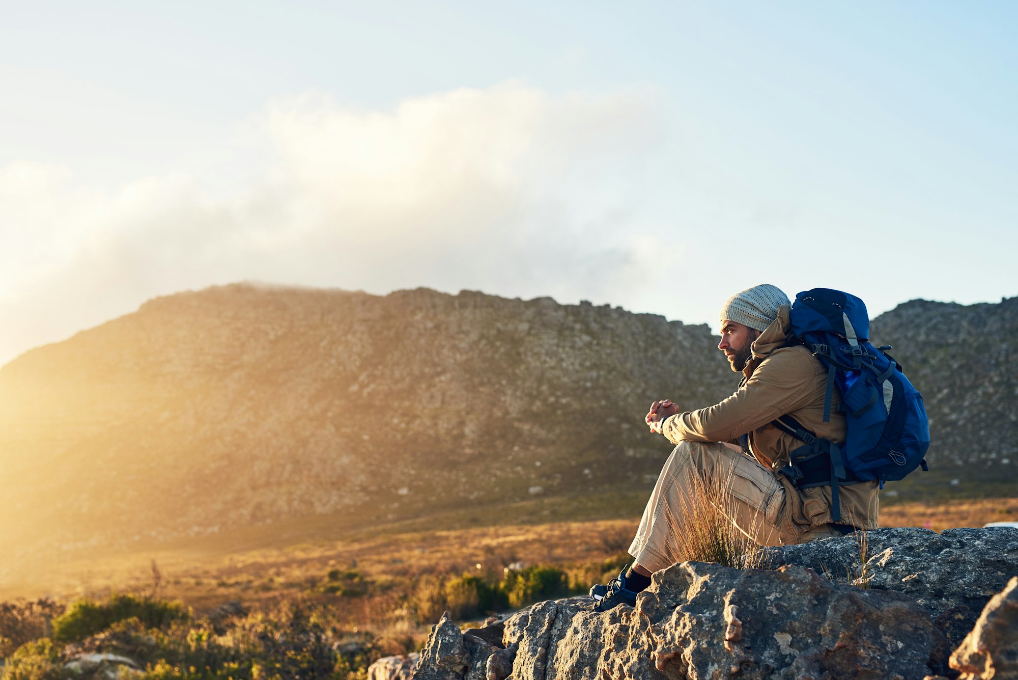 Dont go through life, grow through life. Shot of a hiker sitting on top of a mountain thinking.