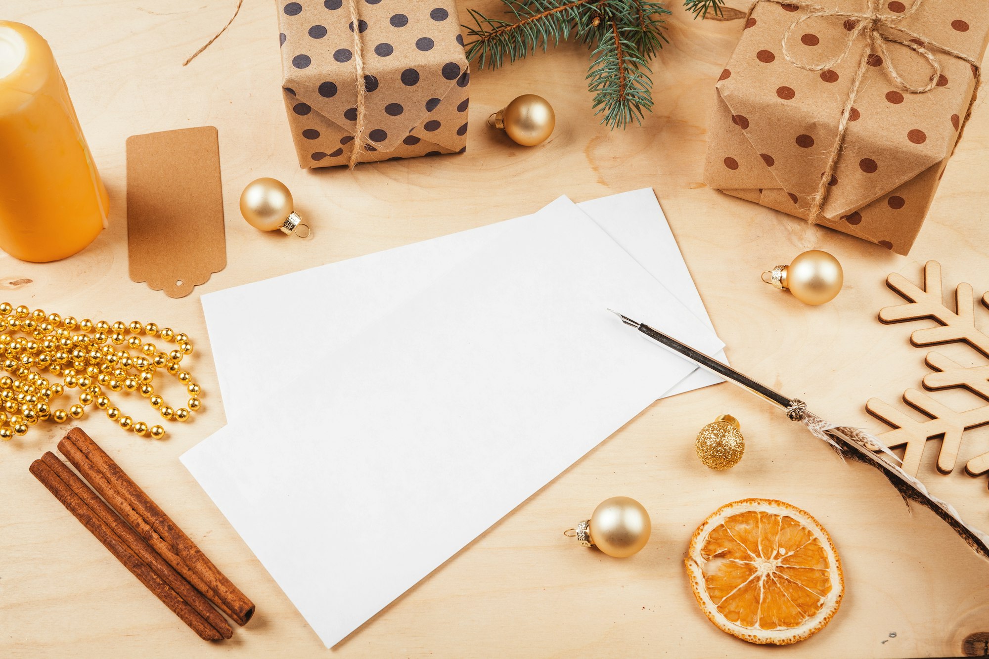 Greeting letter, envelope and feather surrounded by Christmas decorations