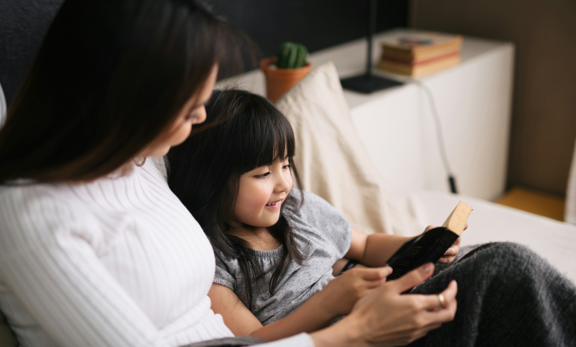 Mother and kid little girl reading a bedtime story