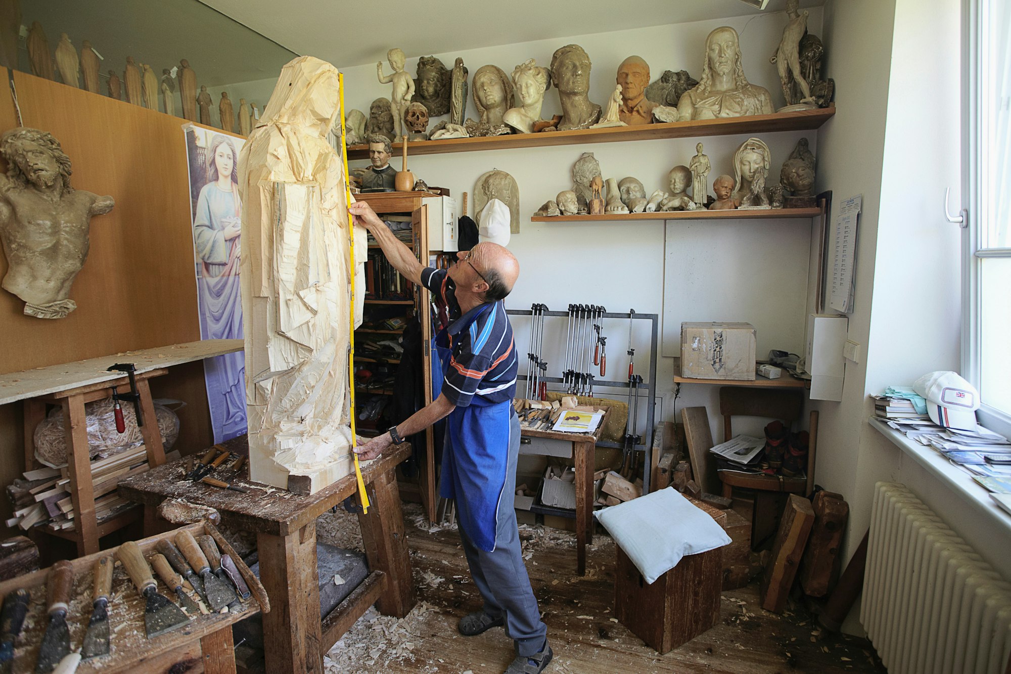 Sculptor measuring wooden figure