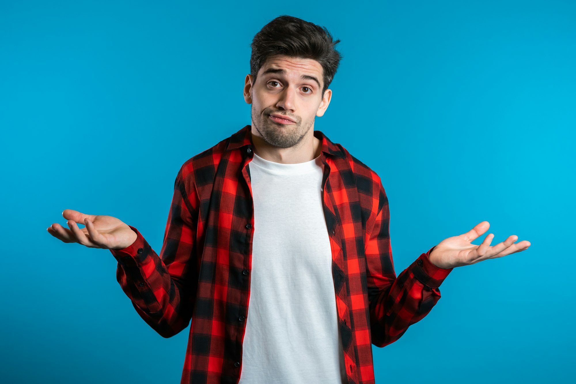 unsure guy in red plaid shirt shrugs his arms, makes gesture of I don't know, can't help anything.