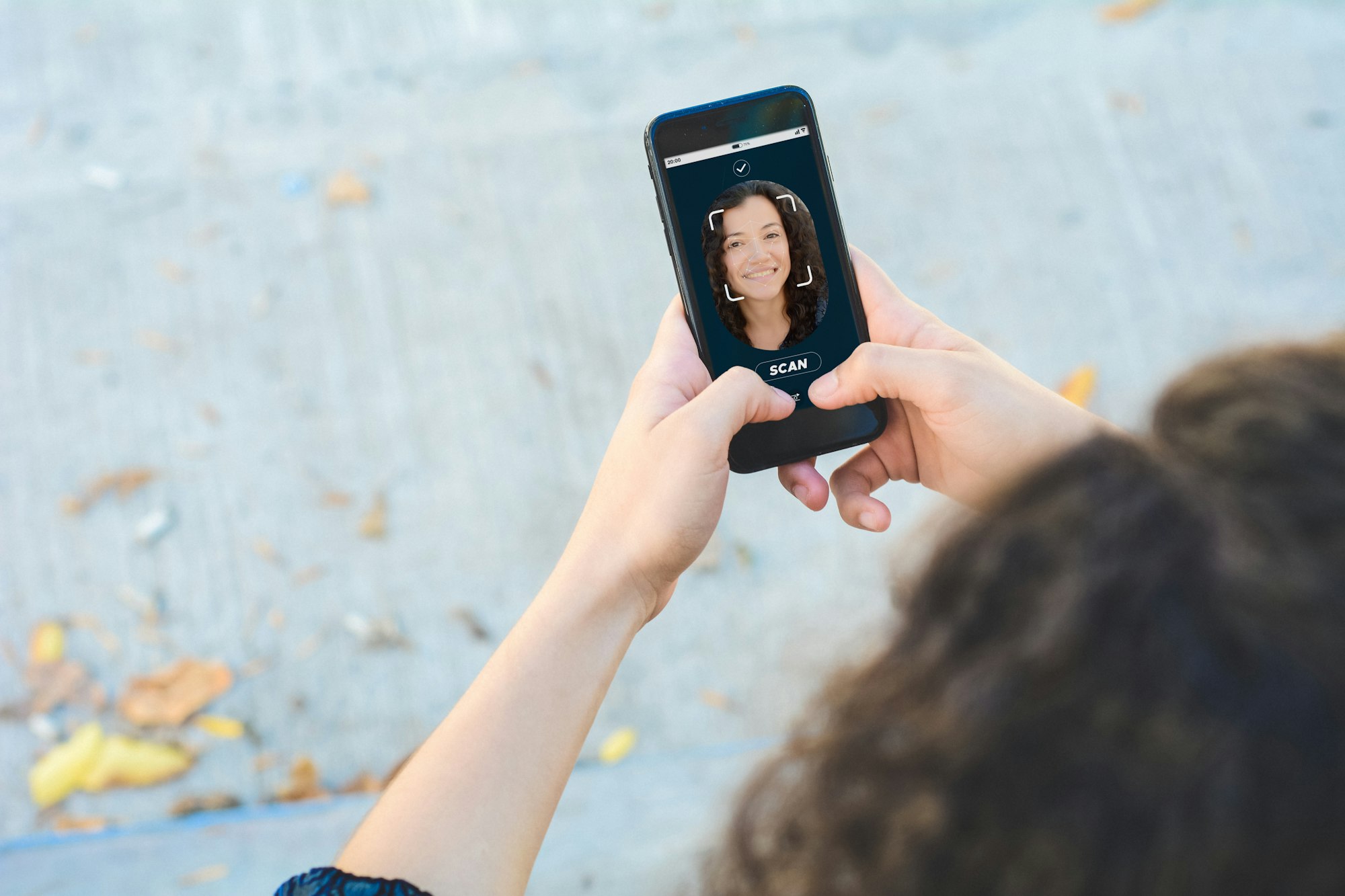 Woman unlocking smartphone with facial recognition technology