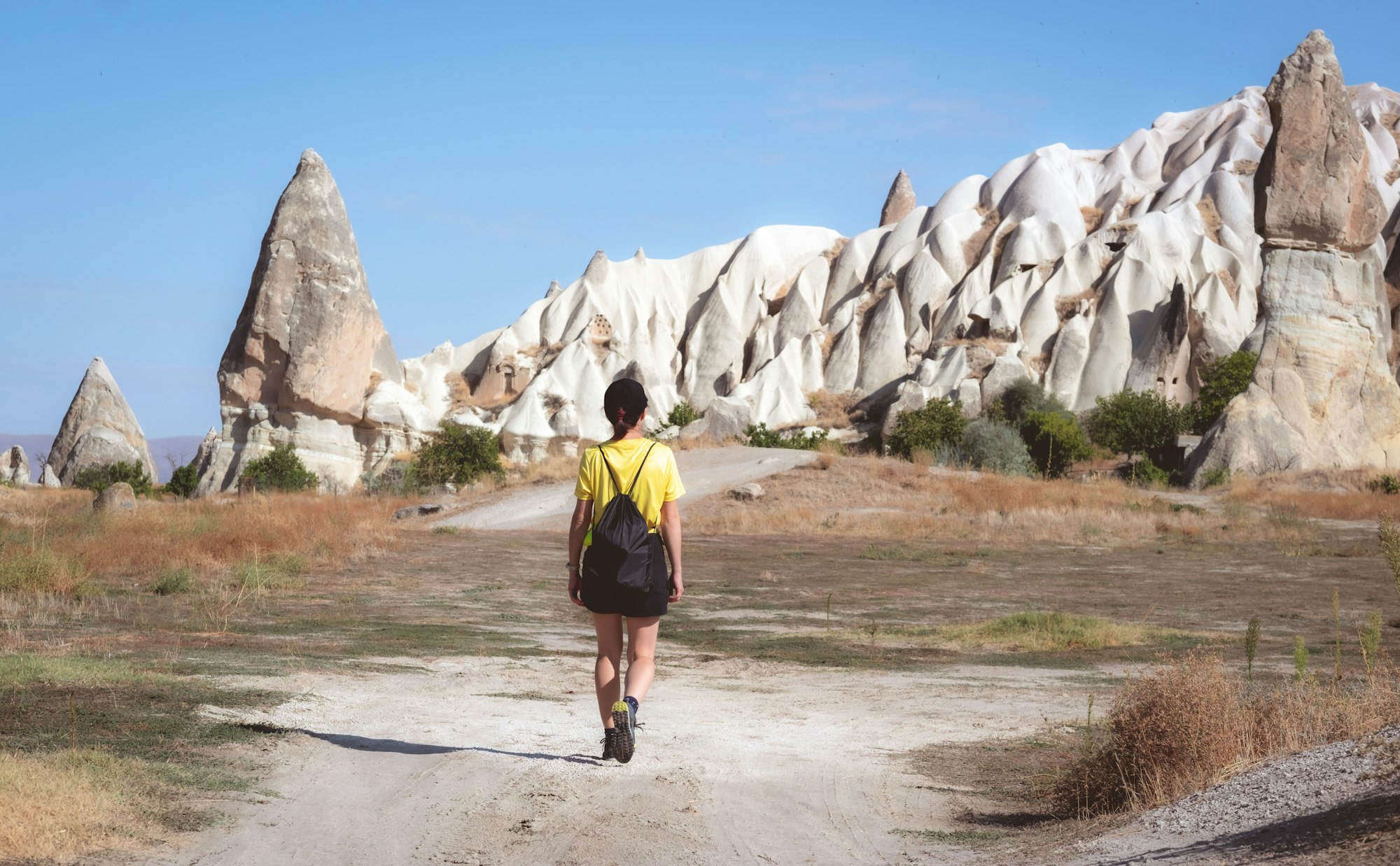 Woman walking towards cave dwellings