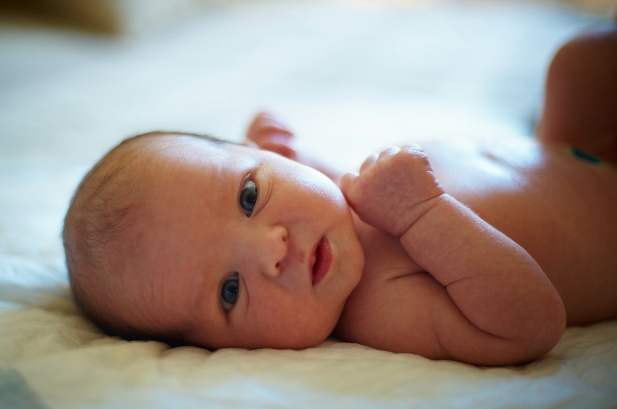 Cute 3 days newborn baby lying in bed at home